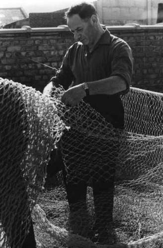 Nettenverkoper Felix De Groote repareert netten te Zeebrugge