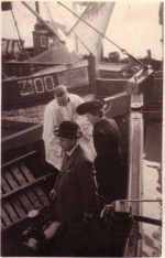 Doop vissersvaartuig met pastoor, meter en peter van het vaartuig 