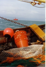 Vissersvaartuig vaart voorbij aan lichtschip