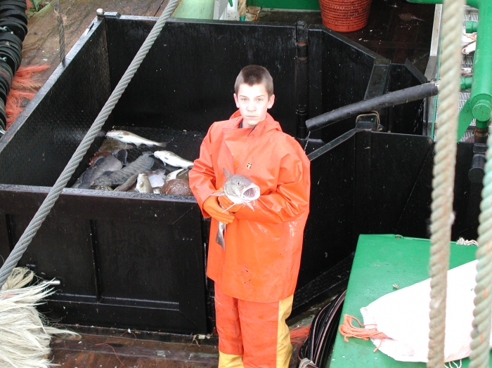 Jongen in oliejas en -broek met vis