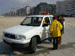 Enkele mensen bij een witte auto tijdens Lenteprikkel in De Panne op 27/03/2004